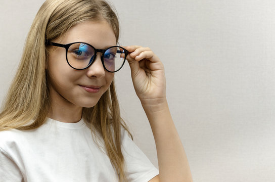Portrait of a smiling beautiful young girl with glasses. Smart child. Nerdy