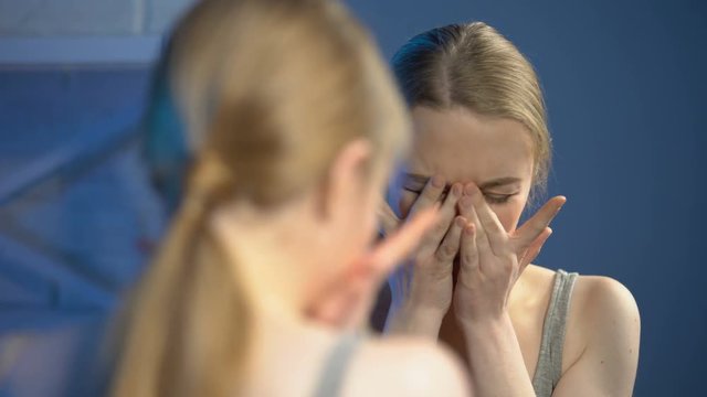 Depressed female looking sadly mirror, unhappy with appearance, adolscence