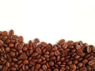Top View of heap of roasted coffee beans on white background with free space for text and design