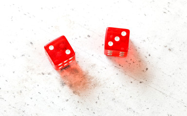 Two red craps dices showing Fever Five Little Phoebe number 2 and 3 overhead shot on white board