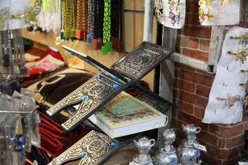 stoisko na bazarze irańskim z dewocjonaliami i pulpitem pod koran