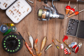 Accesories for fishing on wooden background with copyspace .