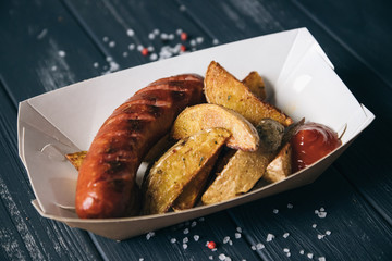 Fried potatoes and grilled sausages. Street food.