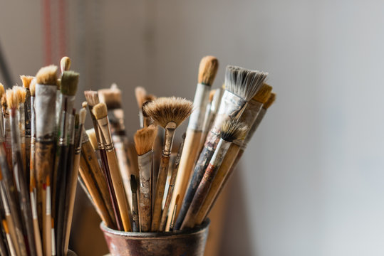 Artist's studio - jar of paint brushes in a workshop with natural light