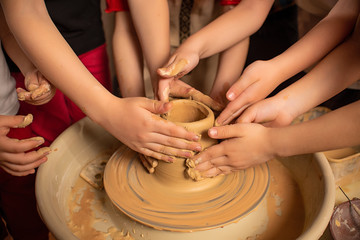 Children's hands work with clay on a special machine. Products from clay. Pottery