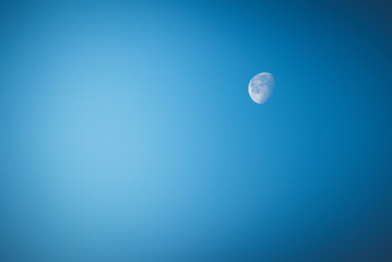 View on a waning moon on the blue sky