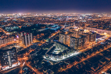 Fototapeta na wymiar Aerial panoramic view, flight on drone above night city Voronezh with illuminated roads and high-rise buildings