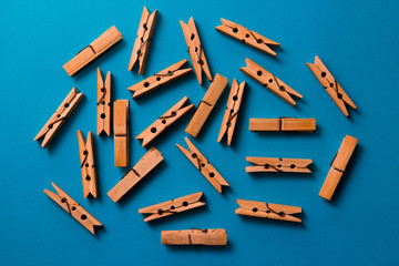 wooden clothespins on a blue background. Flat lay, top view