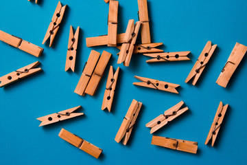 wooden clothespins on a blue background. Flat lay, top view