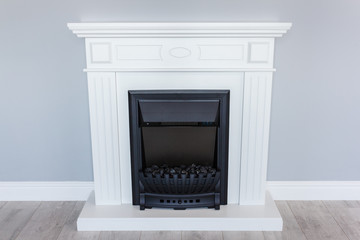  White wooden decorative electric fireplace. Interior photo on gray background.