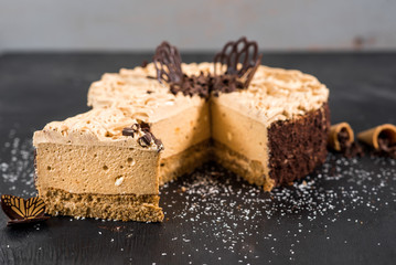 Sweet chocolate cake on the black wooden background