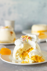 Cottage cheese dessert with apricot filling decorated with whipped cream. 