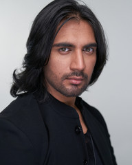 Portrait of Indian man with long black hair in studio