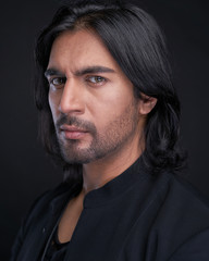 Portrait of Indian man with long black hair in studio