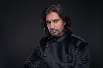 Obraz premium Portrait of Indian man with long black hair in studio