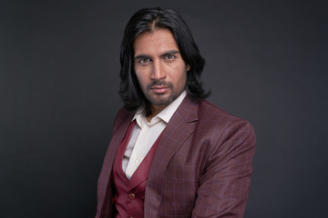 Portrait of Indian man with long black hair in studio