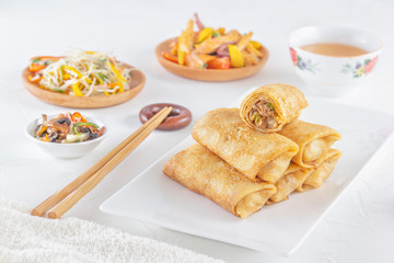 Traditional Chinese tortillas filled - bings in a plate on a white background, salads, Dam Sam snacks and cup of tea.
