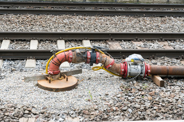 pipe and valve system with sensors and electrical wiring between railroad tracks