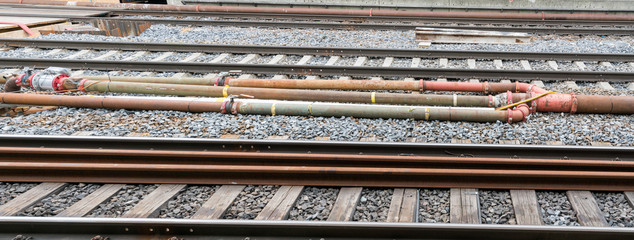 pipe and valve system with sensors and electrical wiring between railroad tracks