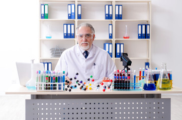 Old male chemist working in the lab 