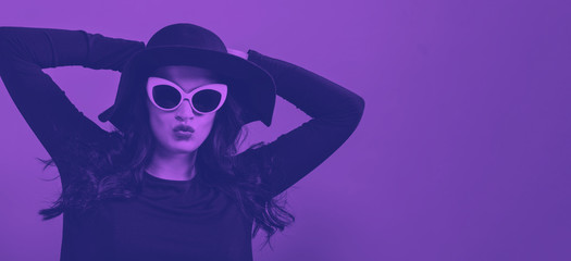 Fototapeta na wymiar Fashionable woman in sunglasses on a pink background with duotone
