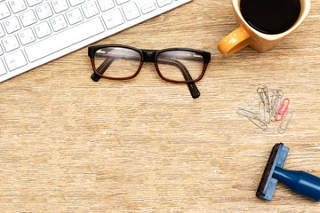 Flat lay photo of office desk with keyboard,  eyeglasses and coffee cup, paper clip and pen. top view