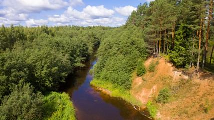 Fototapeta na wymiar High sandy bank of the Polomet River, Novgorod Region, Russia