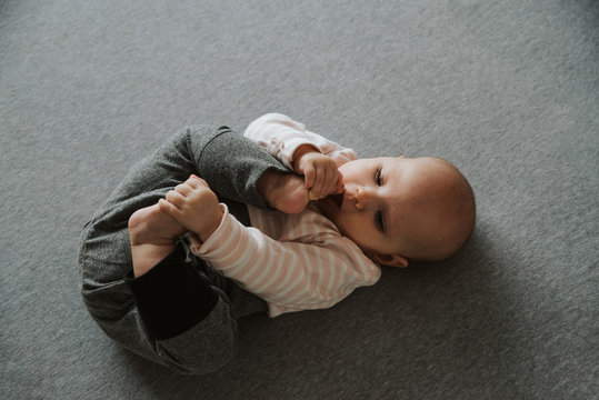 newborn stretching arms and legs on the floor, top view