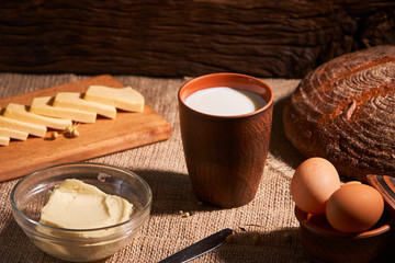 Assorted dairy products milk, cheese, butter rustic still life on table