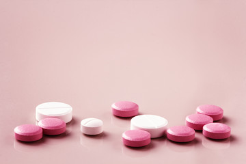 round pills on a pink pastel background with space for text