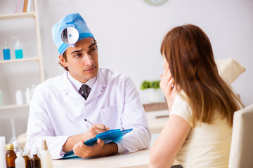 Young woman visting male doctor otolaryngologist