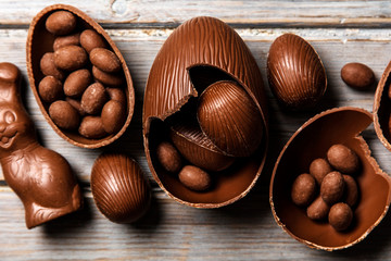 Chocolate easter bunny rabbits and eggs on a rustic wooden background