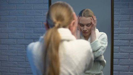 Depressed female in robe suffering stress looking in camera, soul pain, sorrow