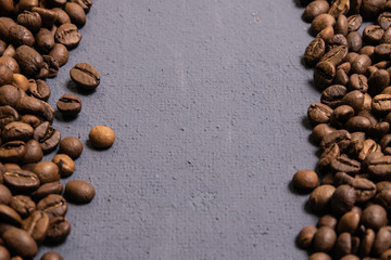 Roasted coffee beans in bulk on a gray concrete background. dark cofee roasted grain flavor aroma...