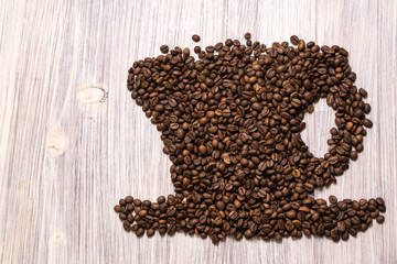 Roasted coffee beans like a cup on a wooden background