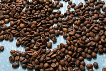 Roasted coffee beans in bulk on a blue wooden background