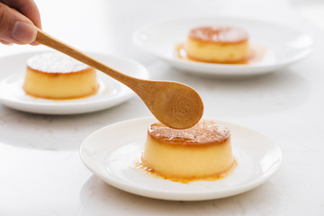 Delicious vanilla custard in caramel sauce with spoon