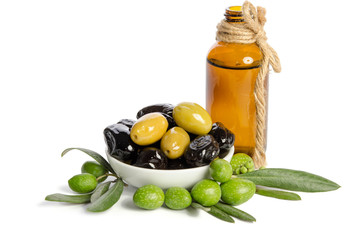 Black and green  olives  mixed in the  porcelain bowl and Virgin olive oil in a crystal bottle isolated on white background