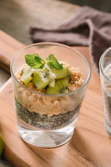 Healthy breakfast - bowl of muesli, berries and fruit, nuts, kiwi, milk