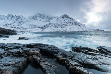 Amazing day in Mountains And Fjords, Winter Landscape, Norway Clouds sky on the Norwegian Alps and the blue hour begins in range at Senja, Norway. Beautiful christmas time near Troms county.