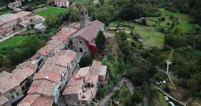 CASTELLLFOLLLIT DE LA ROCA, SPAIN - NOVEMBER 04, 2018:  Aerial view of Castellfollit de la Roca, medieval Catalan hamlet on cliff on autumn day