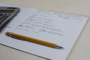 math formulas in notebook, pencil and calculator