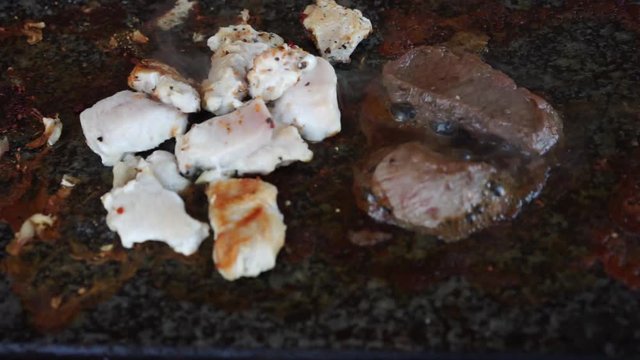 Meat cooking on hot stone grill