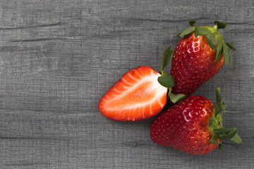 Heap of fresh strawberry on wooden grey table with copy space. Food photography background