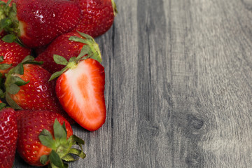 Heap of fresh strawberry on wooden grey table with copy space. Food photography background