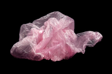 Fototapeta premium Pink plastic bag with handles on a black background isolate.