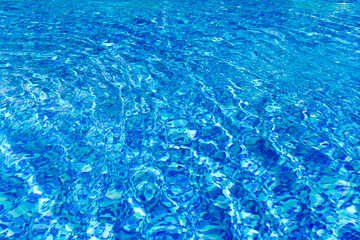 Blue pool water with sun reflections