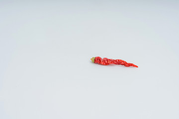 Red hot chili peppers on a white background. Dry, shriveled red pepper. Dehydration of vegetables.