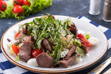Meat salad with roast beef, vegetables and cheese on a plate. Roast beef salad.
