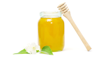 honey dipper and honey in jar on white background